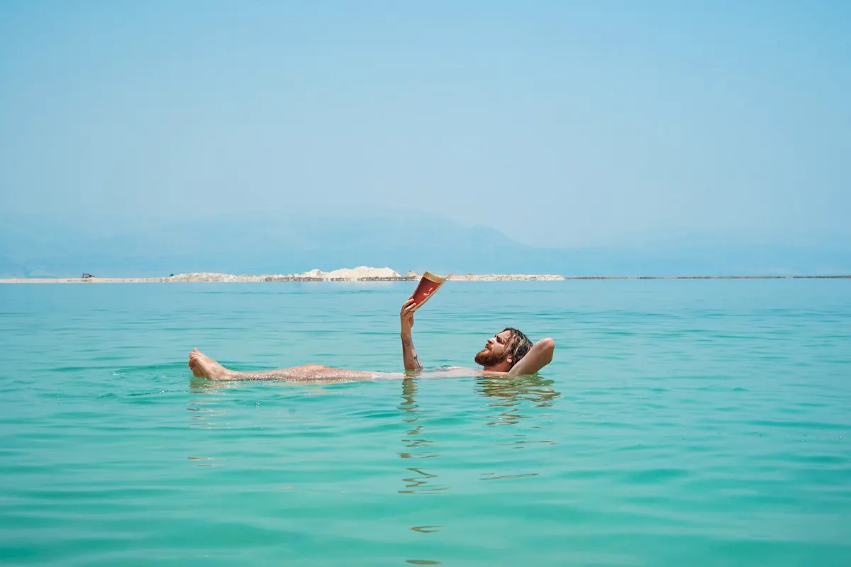 Someone floating in the water, reading a book
